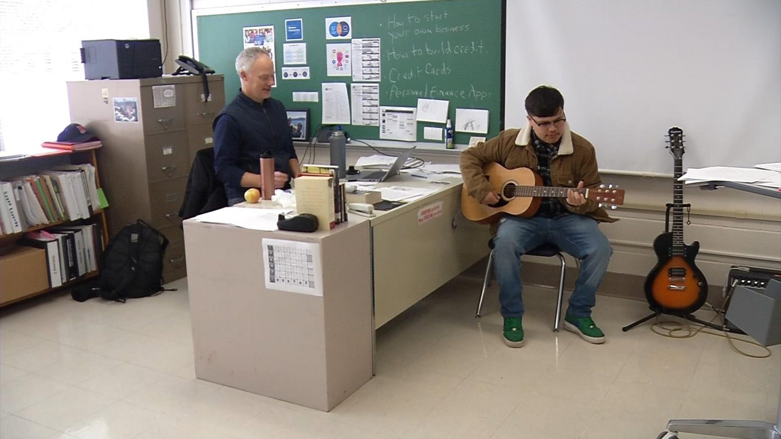 Robbinsdale Academy-Highview student Jose Vazquez-Krogstad  plays the guitar as his teacher looks on