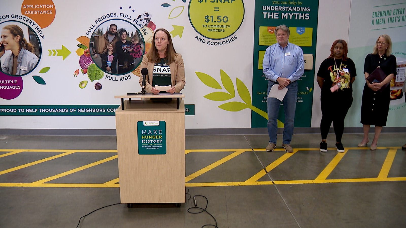 Woman stands at a Second Harvest Heartland podium 