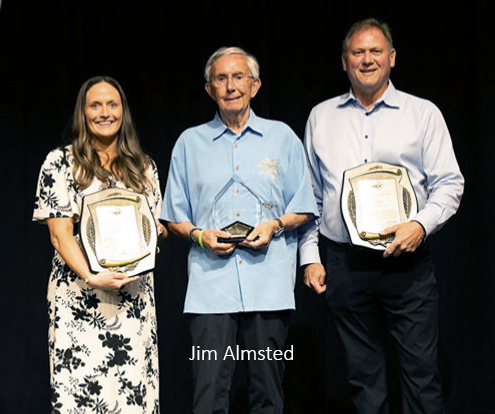 three people holding up award plaques 