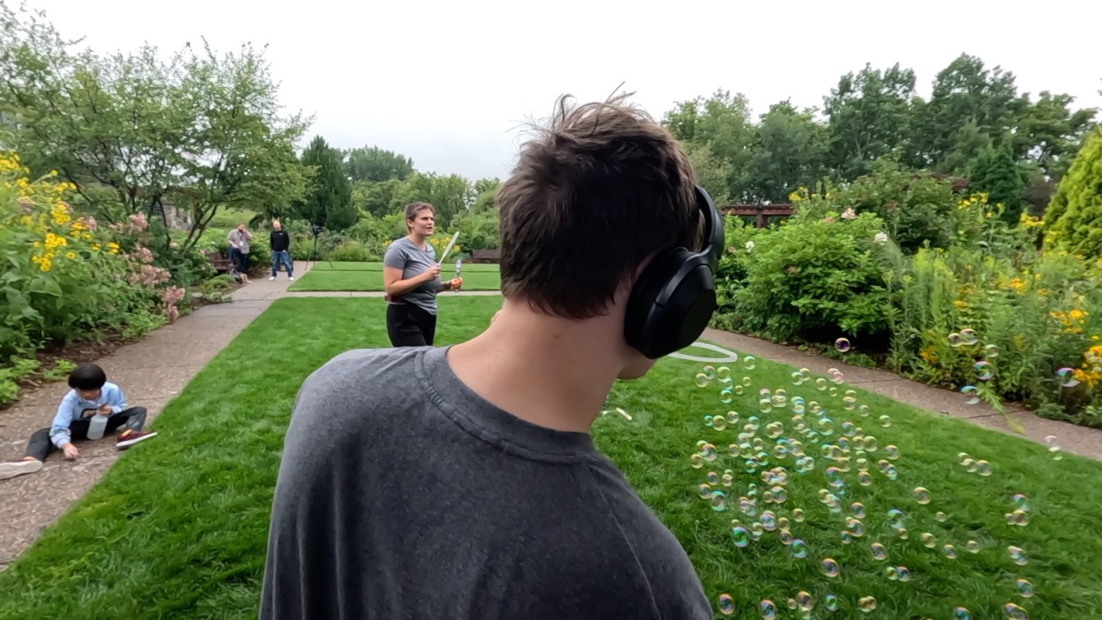 a boy with special needs enjoys bubbles outside in a city garden in Plymouth