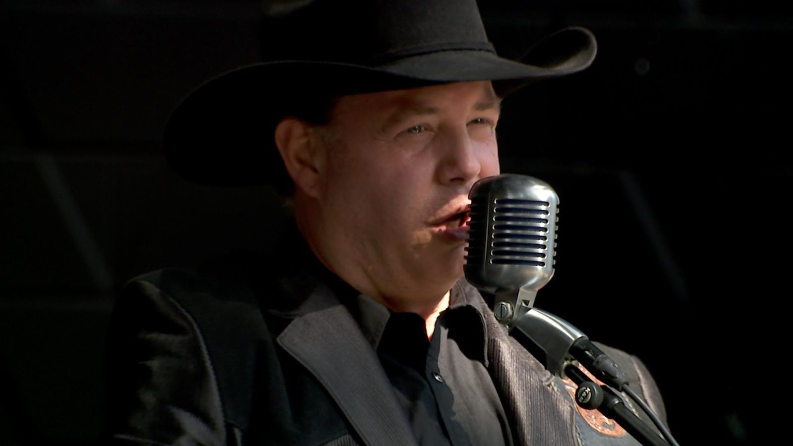 Jay Ernest sings into a microphone