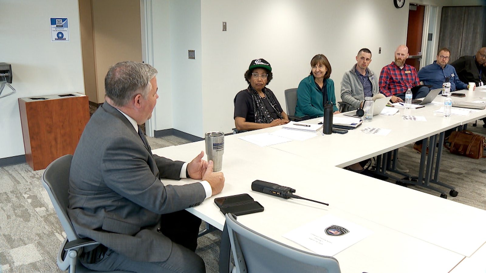 several police chaplains sit around a table with a police officer