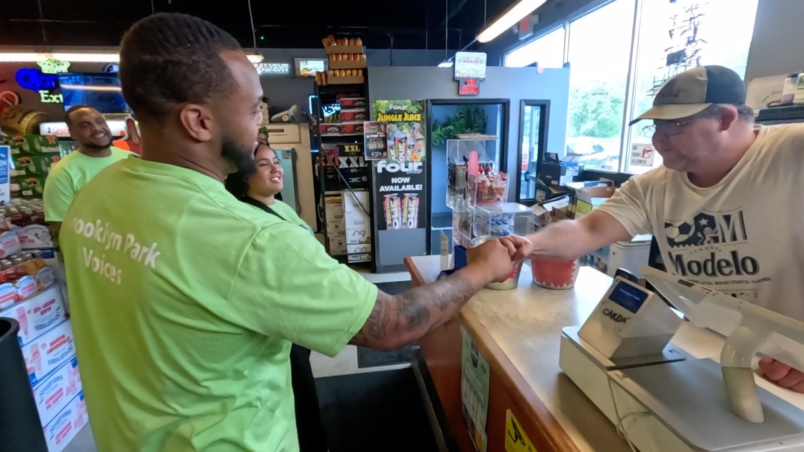 Staff member with the City of Brooklyn Park fist bumps the owner of a liquor store.