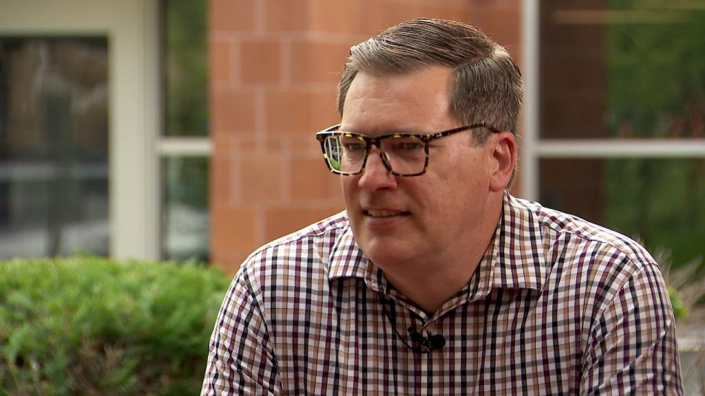 A man with glasses and a plaid shirt