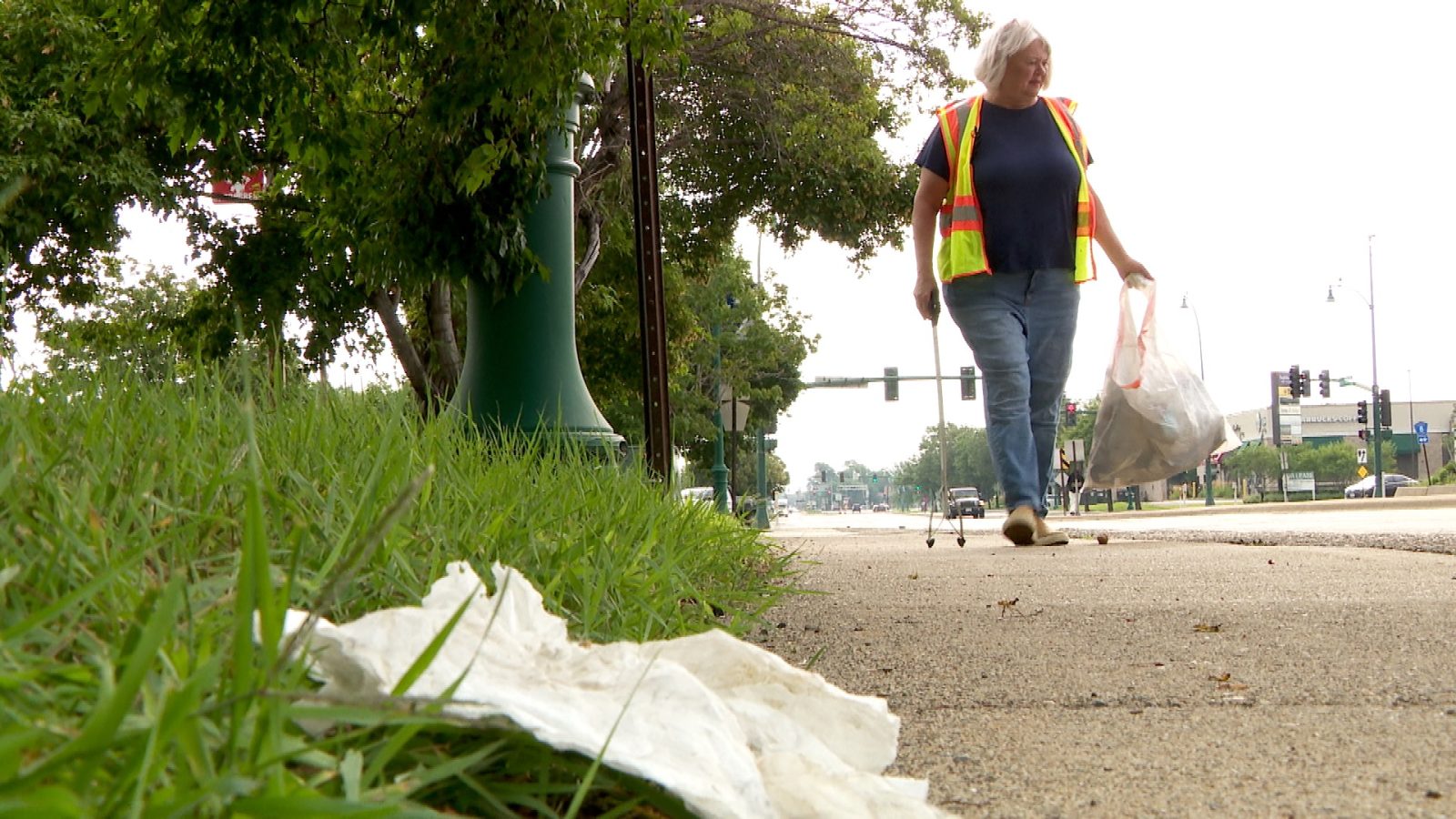 a piece of litter along a sidewalk in Crystal about to be picked up and disposed of by Mayor Julie Deshler