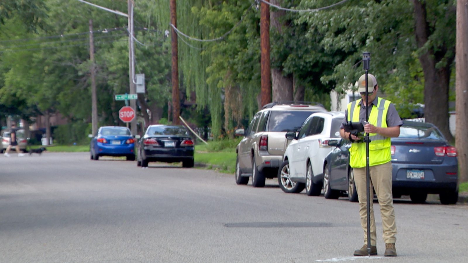 image of man in a protective safety vest in the street as he conducts surveying as part of his internship in Robbinsdale