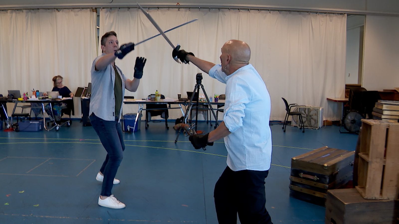 two men practice stage sword fighting