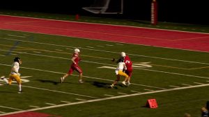 Four football players run for a touchdown.
