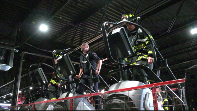 police and firefighters climbing on a stairmaster