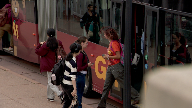 students getting onto a bus at the university of minnesota