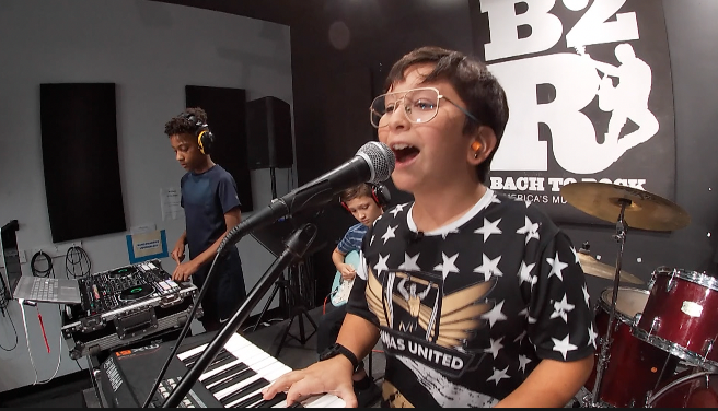 kids on stage playing a song
