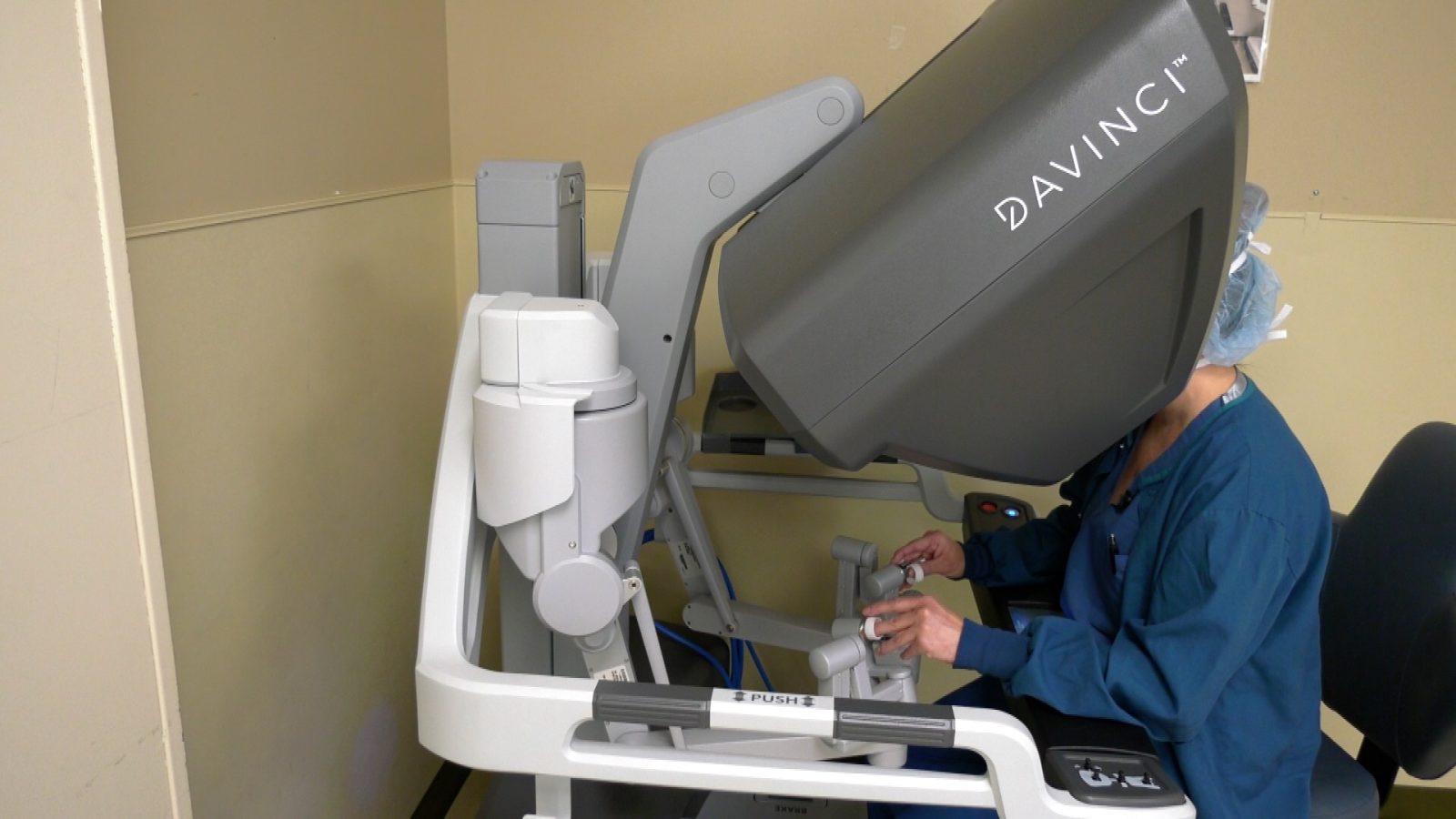 surgeon sitting at robotic console