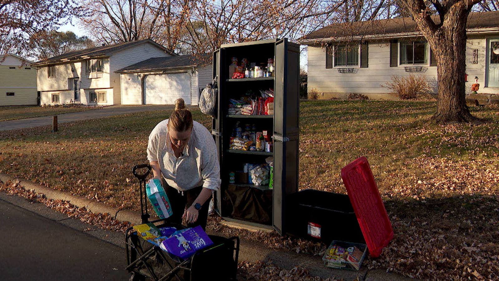woman putting items in an outdoor cabinet