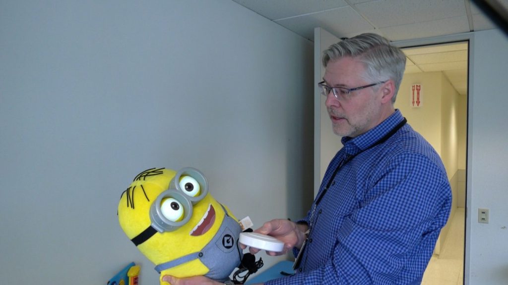 man holding a minion toy adapted with a button