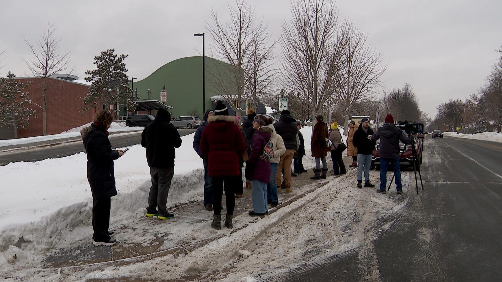 parents stand on a sidewalk outside fair school crystal