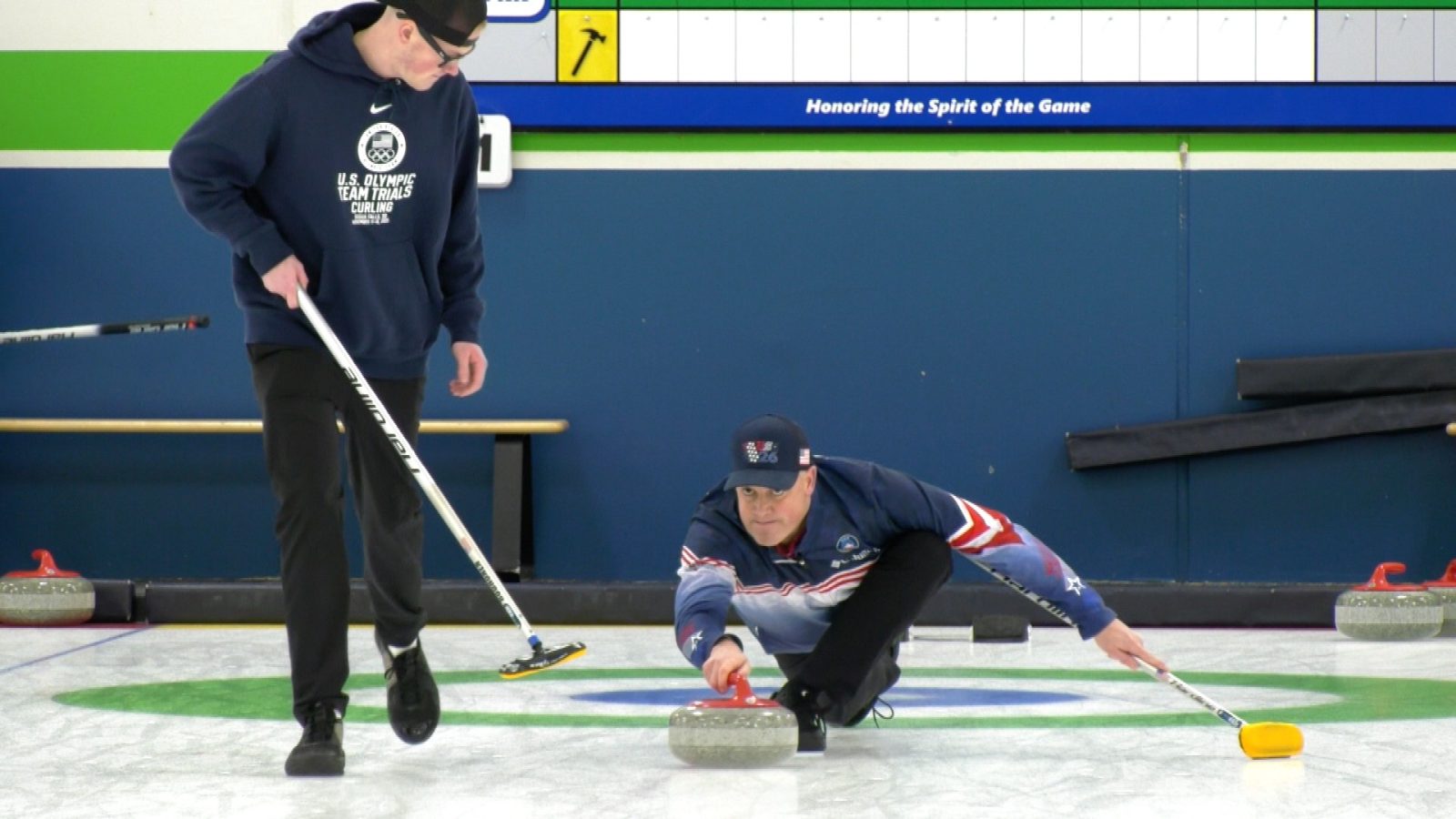 man curling on the ground with another man watchng