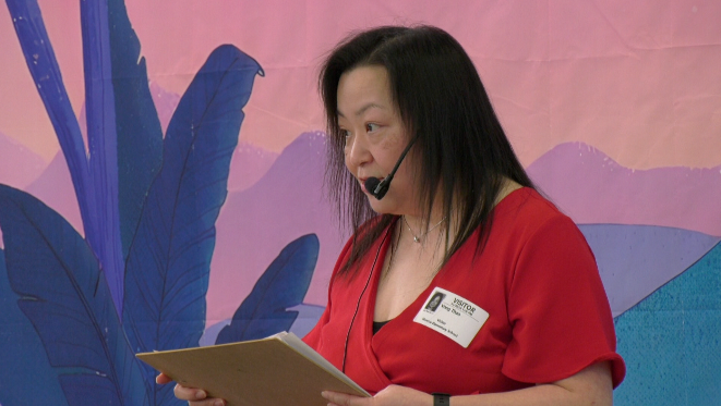 woman in red shirt holds a clipboard