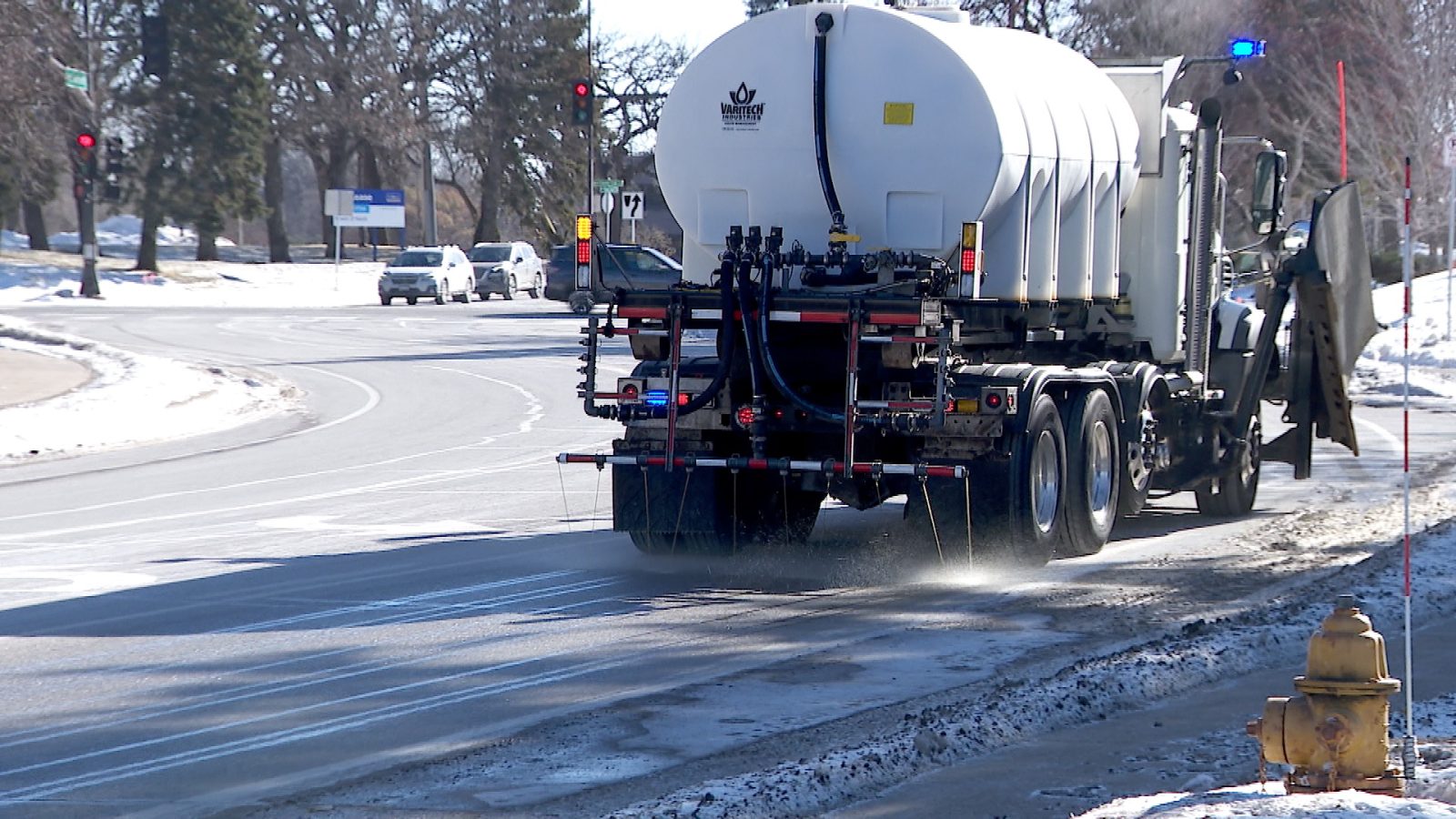 a truck deposits a salt-water brine on a street in winter