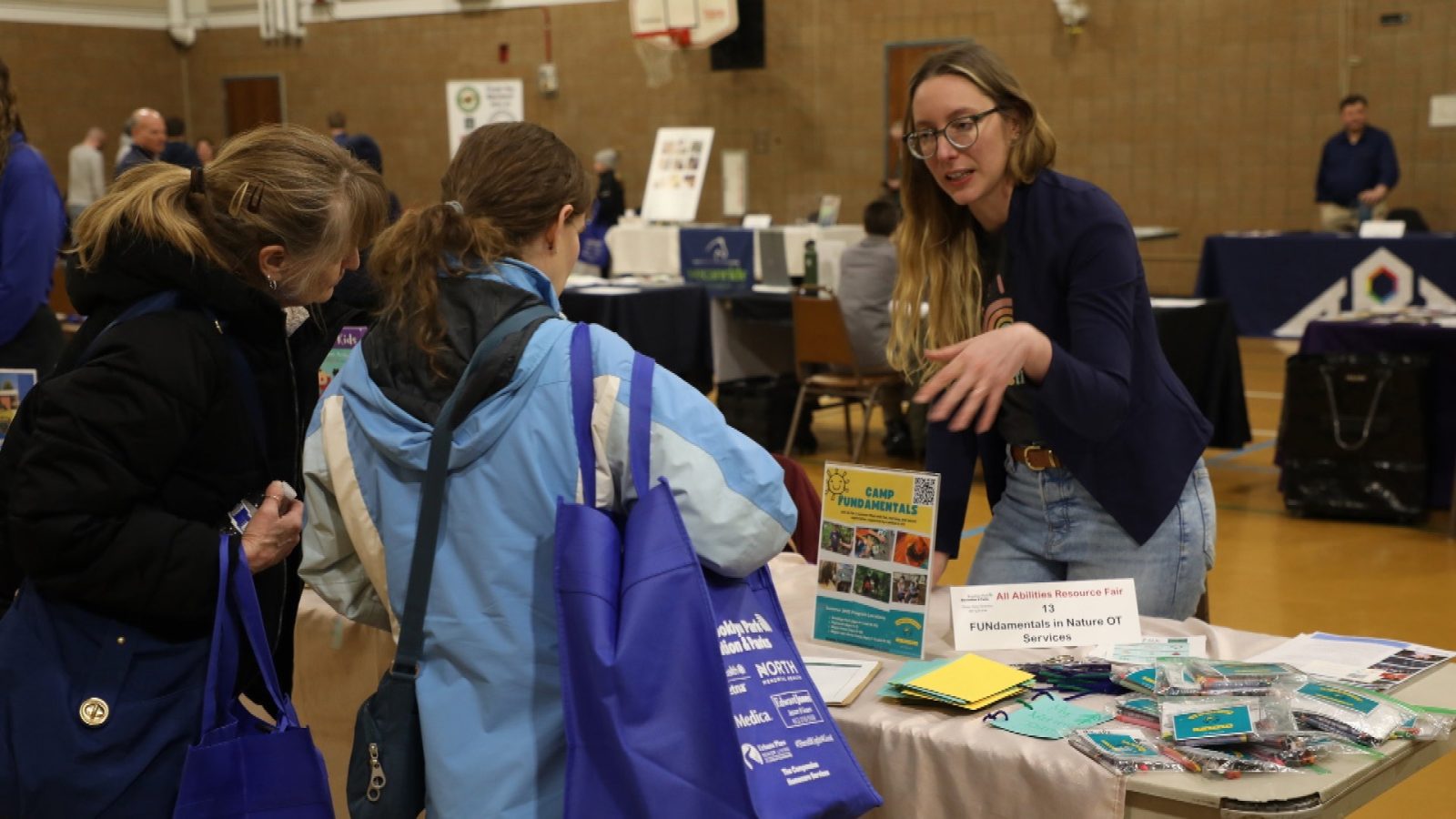 a family talks with the representative of a local organization at an informational fair