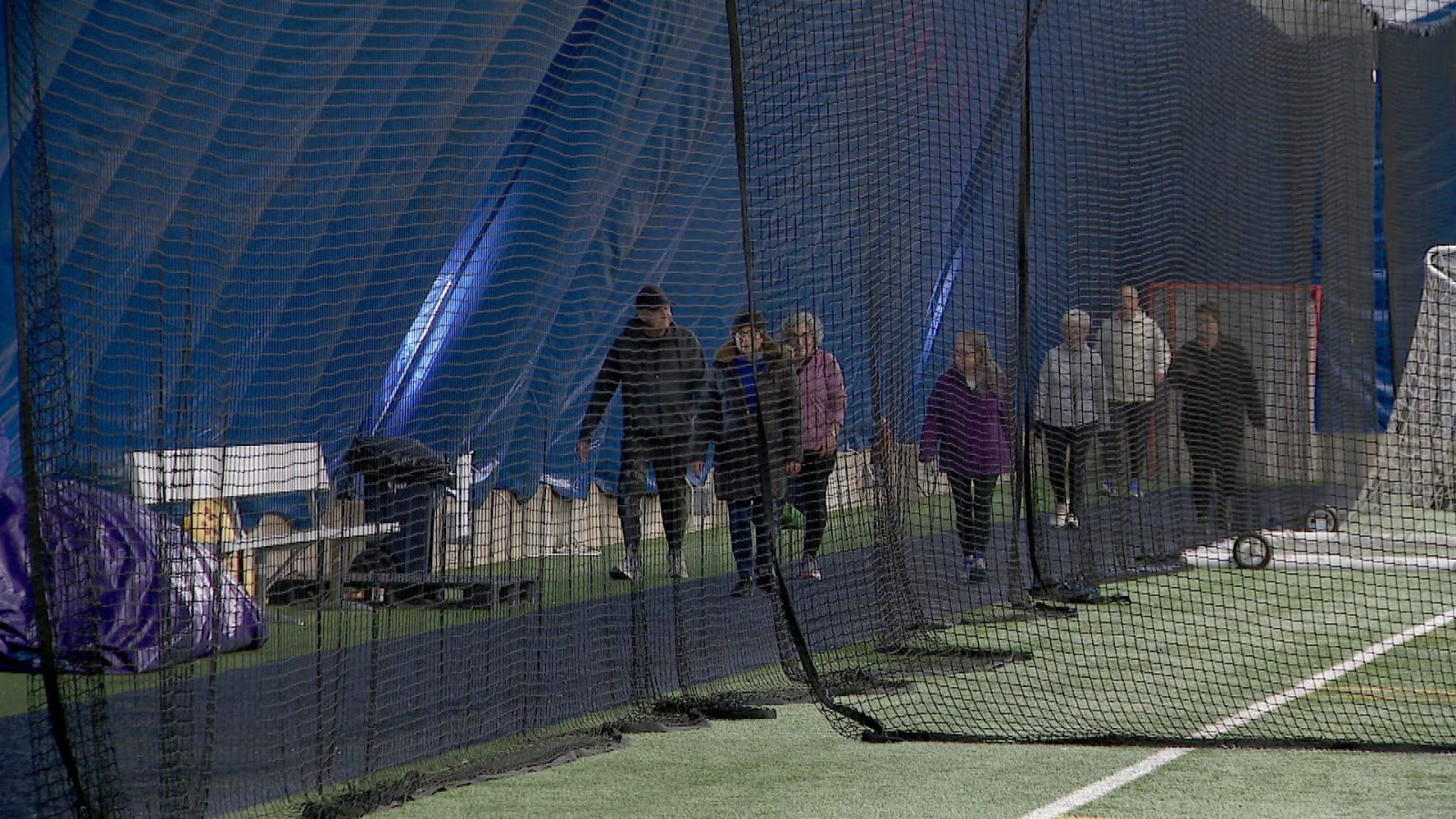 people walking for exercise around the inside of an inflatable domed fieldhouse