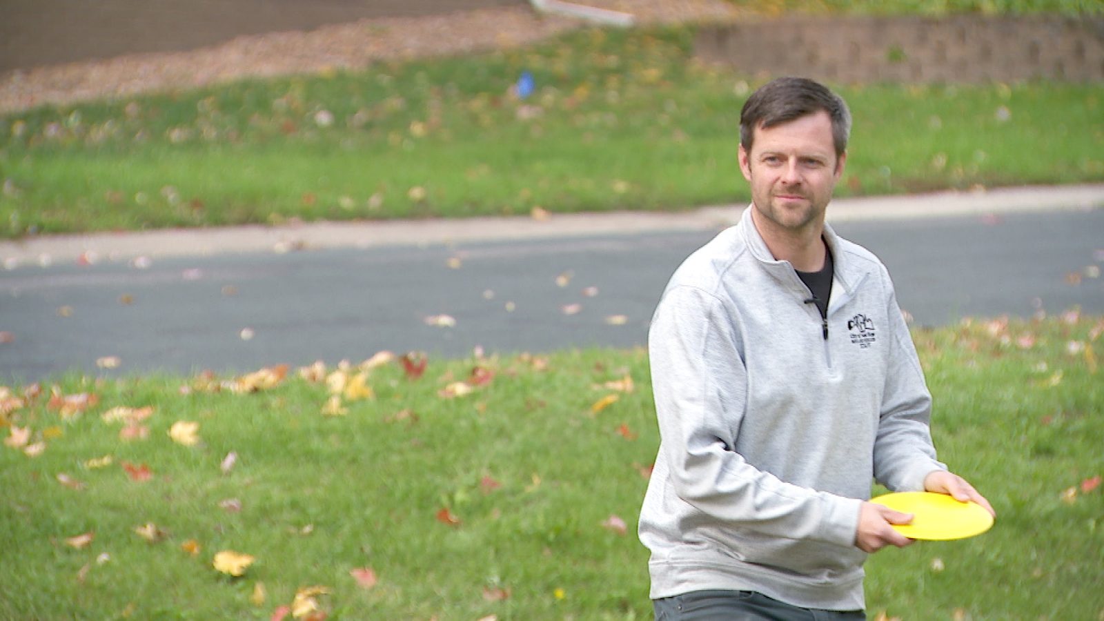 man poised to toss a frisbee in a park