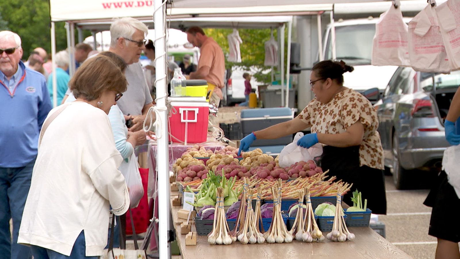 Shoppers browse fresh produce at an outdoor farmer's market
