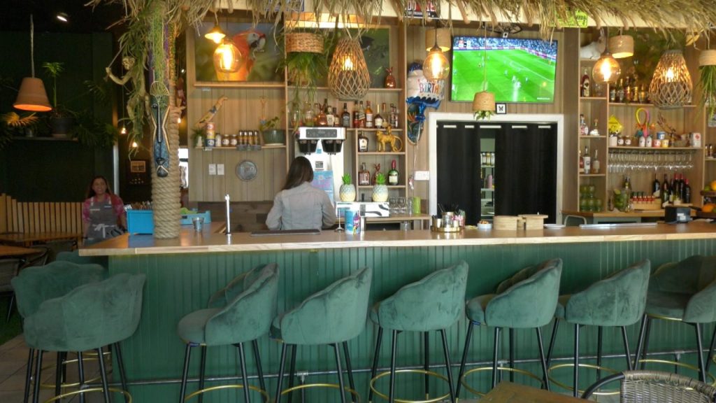 bar with teal chairs and tiki-themed decor
