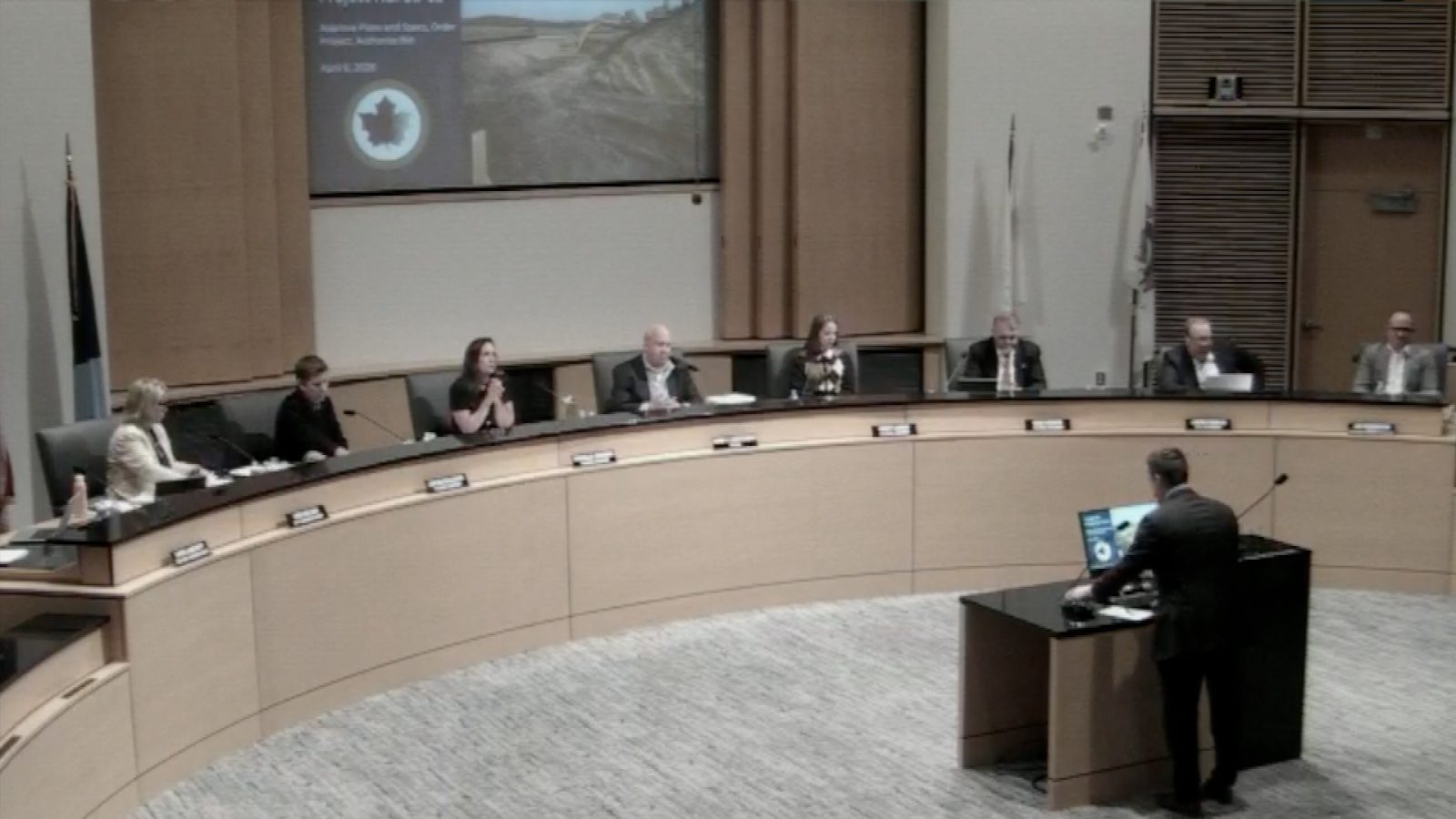 Members of a city council seated around a dais during a meeting