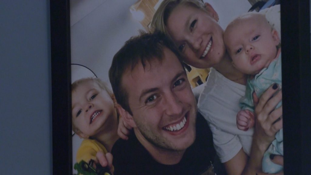 a toddler, their parents and a baby smile for a photo