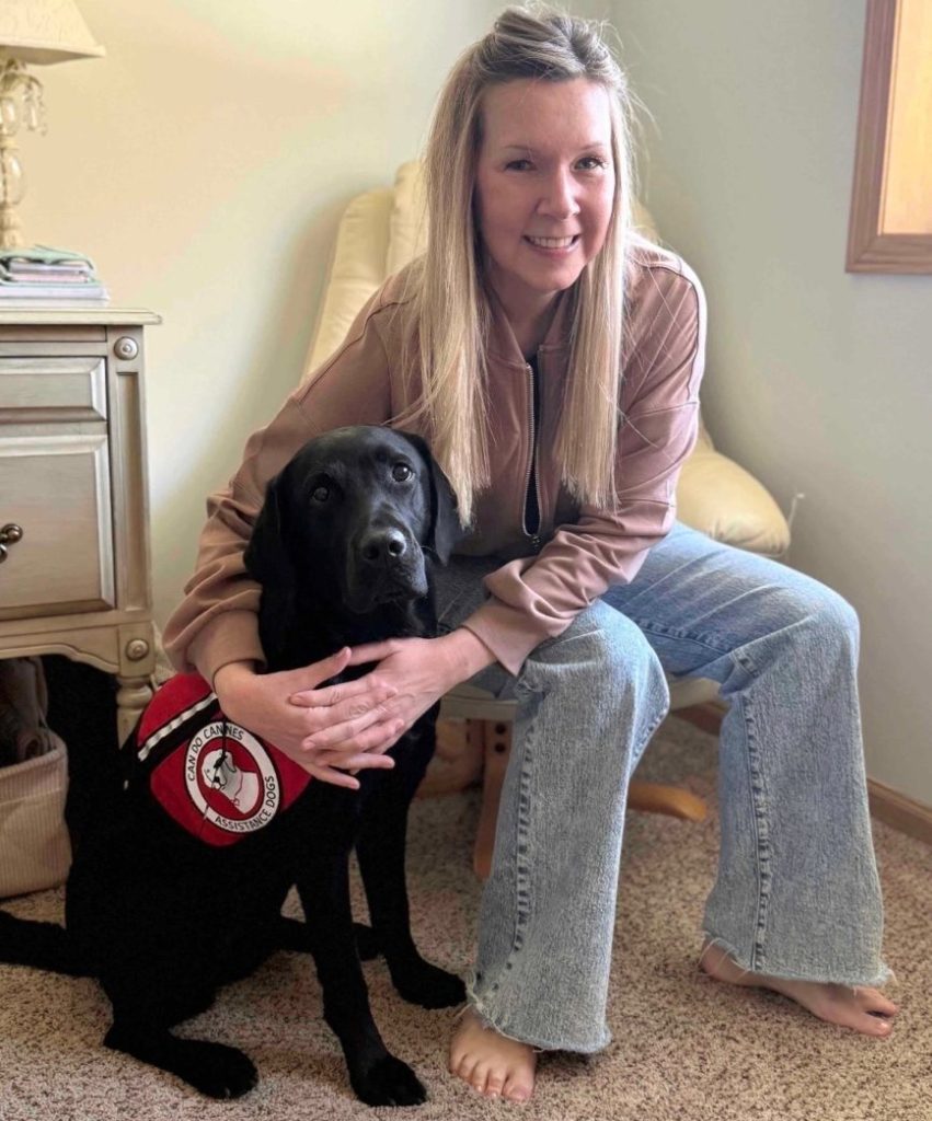 Woman with a black lab service dog