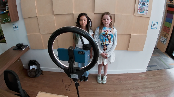 students talking into a cell phone during an audition for the Netflix show 'Schooled' at Code Ninjas.