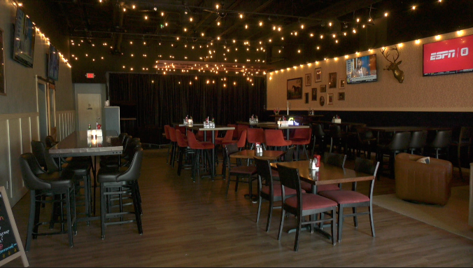 the revival room at rock elm revival is a private dining area filled with tables, chairs and a stage for live music