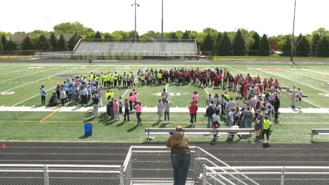 students gathered on the champlin park football field