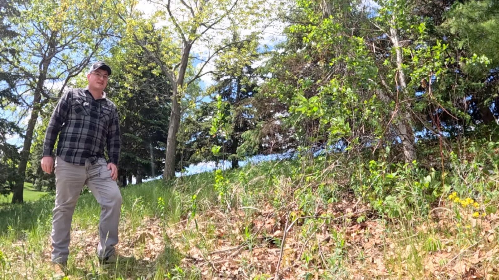 man standing on a brushy hillside
