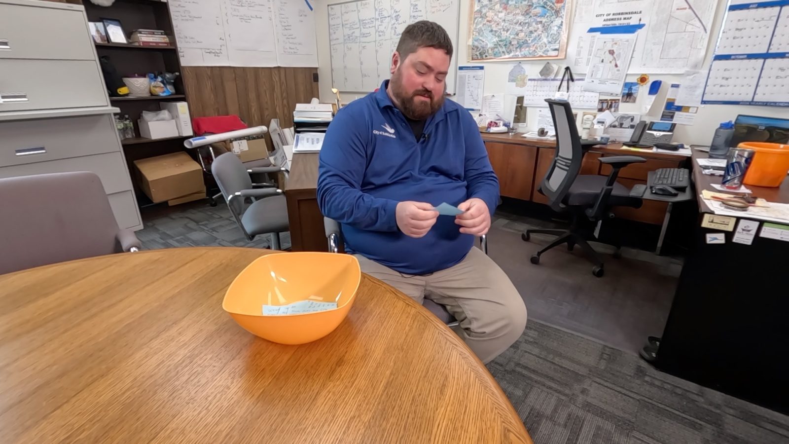 man in an office reads a slip of paper