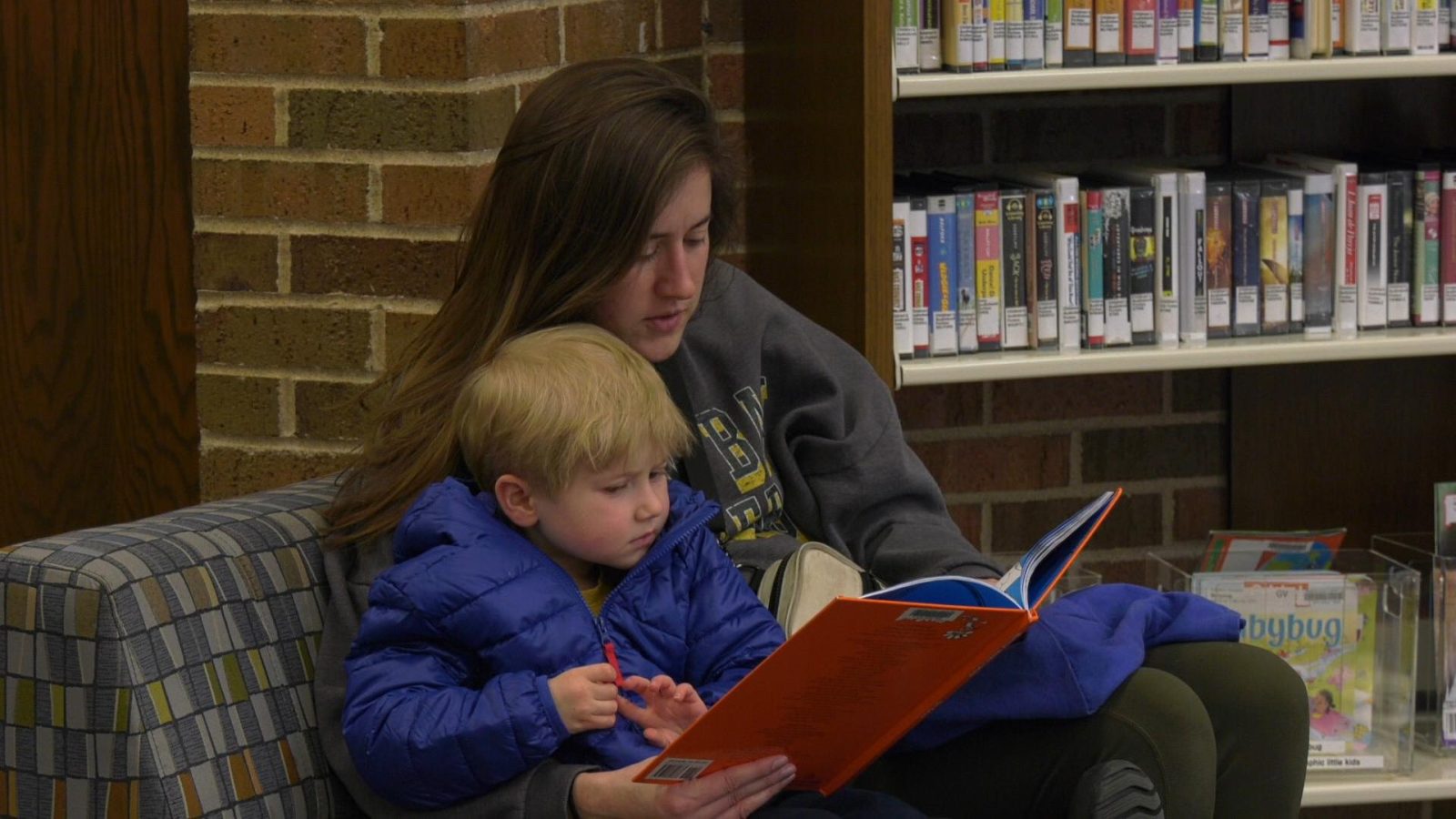 woman reads a book to a child