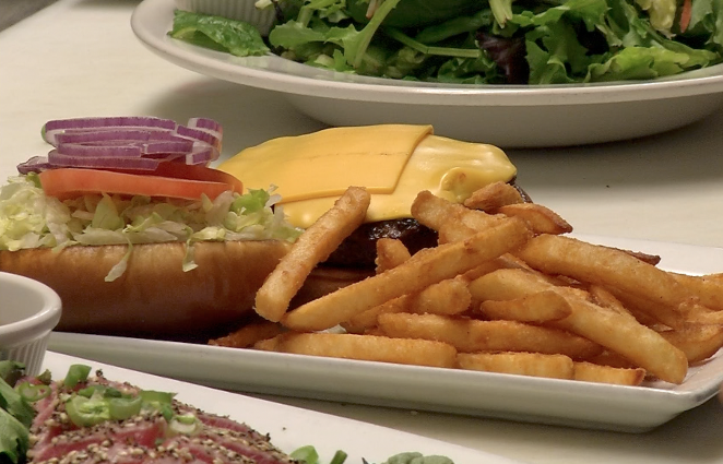 a cheeseburger and french fries sitting on a counter at chanticlear pizza